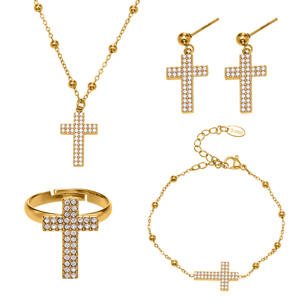 Gold cross jewelry set with sparkling crystal stones, including necklace, earrings, ring, and bracelet